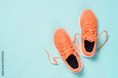 Quadro su tela Pink sneakers at blue background top view.