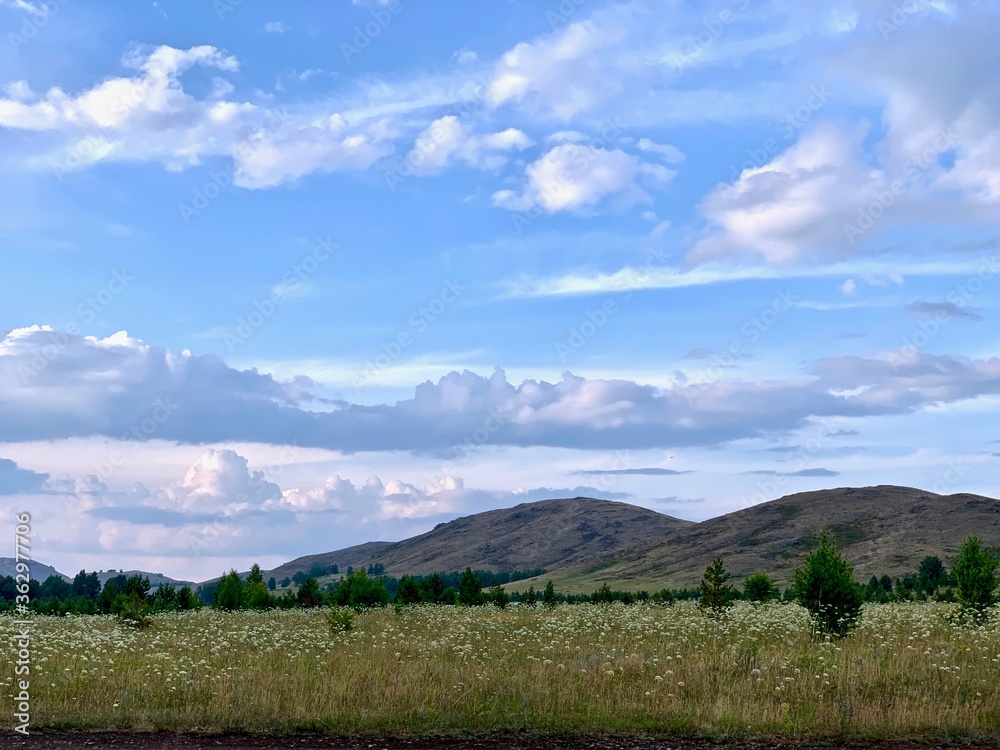 Field in mountainous rural area. beautiful countryside scenery with lovely sky on a summer day
