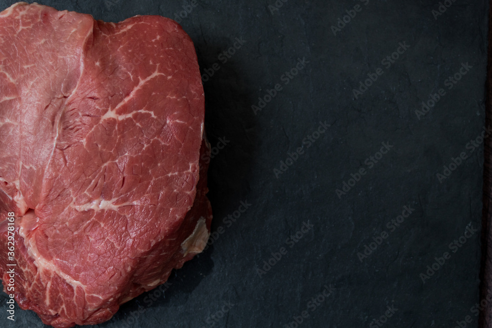 Meat on a black board. A sign on a wooden table. High quality photo