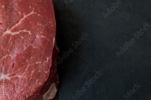 Meat on a black board. A sign on a wooden table. High quality photo