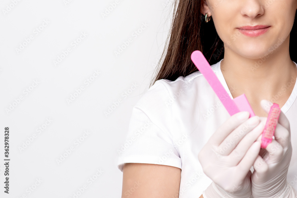 Portrait of beautiful young caucasian woman manicure master holding manicure tools on white background Portrait of beautiful young caucasian woman manicure master holding manicure tools on white background