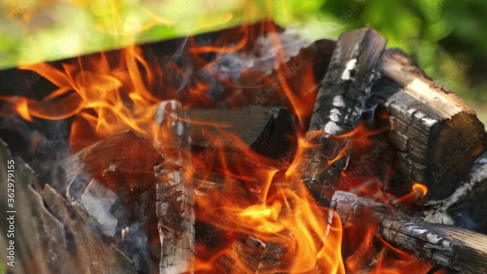 Hot charcoals in fire. Logs of wood smoldering and flaming. Wooden logs burning for barbeque outdoors. Hot charcoals in fire. Logs of wood smoldering and flaming. Wooden logs burning for barbeque outdoors.
