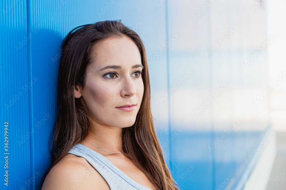 Face portrait of a beautiful young woman smiling with blue background Face portrait of a beautiful young woman smiling with blue background