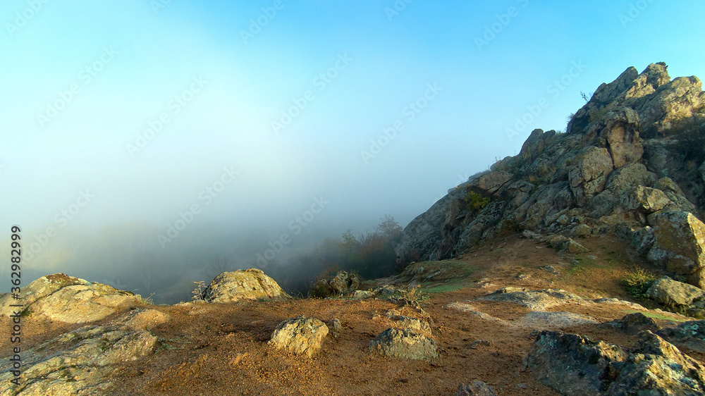 Misty dawn on the from pile of huge stones of rocks in the autumn
