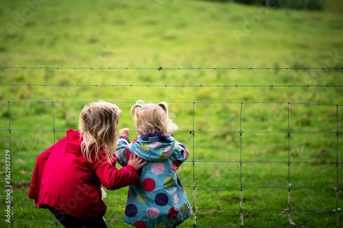 little girls looking over the fence