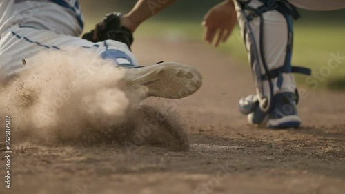 Sliding into home. A runner tries to slide into home plate. Back catcher tags the runner and it's a close call in a dustup. Shot in slow-motion and in 4k. 