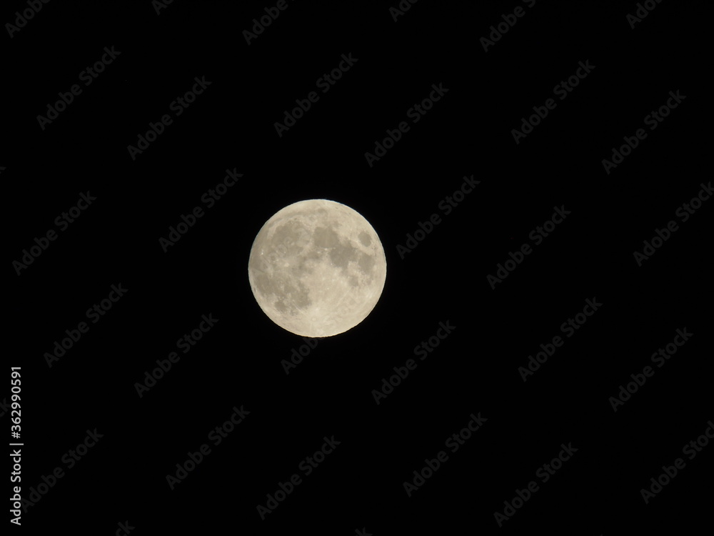 Genova, Italy - 07/05/2020: An amazing photography of the full moon over the city of Genova by night with a great clear and blue sky in the background and some stars. Genova, Italy - 07/05/2020: An amazing photography of the full moon over the city of Genova by night with a great clear and blue sky in the background and some stars.
