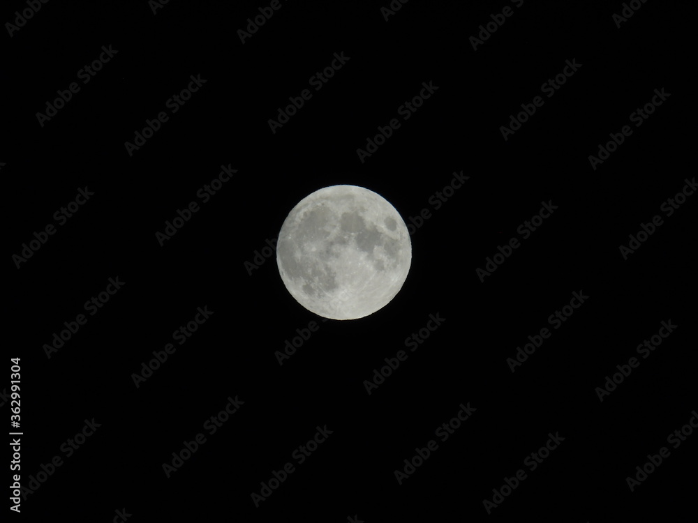 Genova, Italy - 07/05/2020: An amazing photography of the full moon over the city of Genova by night with a great clear and blue sky in the background and some stars. Genova, Italy - 07/05/2020: An amazing photography of the full moon over the city of Genova by night with a great clear and blue sky in the background and some stars.