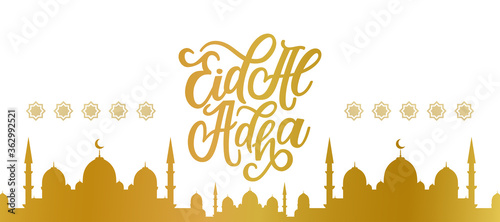 Eid al-Adha Mubarak golden calligraphic inscription translated into English as Feast of the Sacrifice. Golden mosque. Arabic design background. Handwritten greeting card, invitation etc
