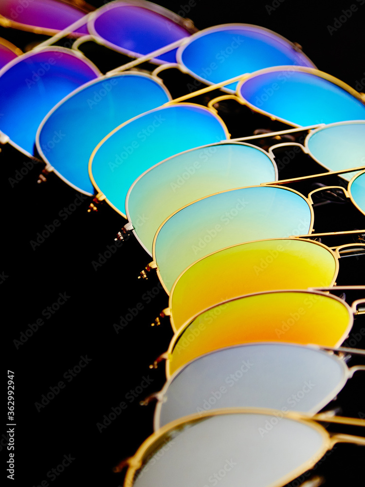 Sunglasses with colorful lenses on black background