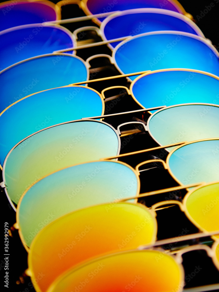 Sunglasses with colorful lenses on black background