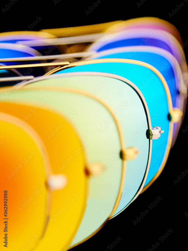 Sunglasses with colorful lenses on black background