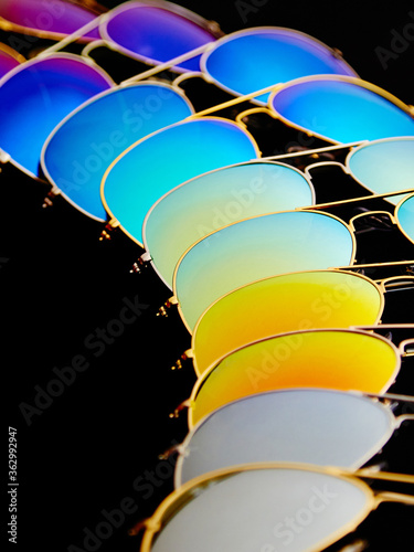 Sunglasses with colorful lenses on black background