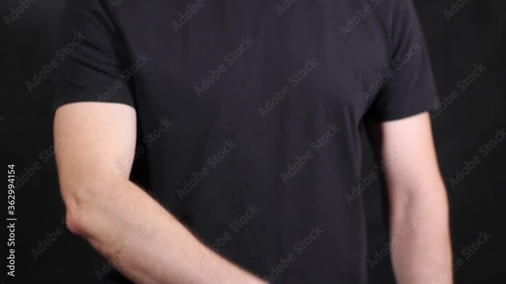 Caucasian male hands in a black short-sleeved T-shirt, pulling a fist Caucasian male hands in a black short-sleeved T-shirt, pulling a fist