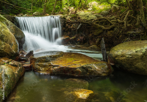 waterfall in a stream in the forest. Panoramic multiple shoot composite