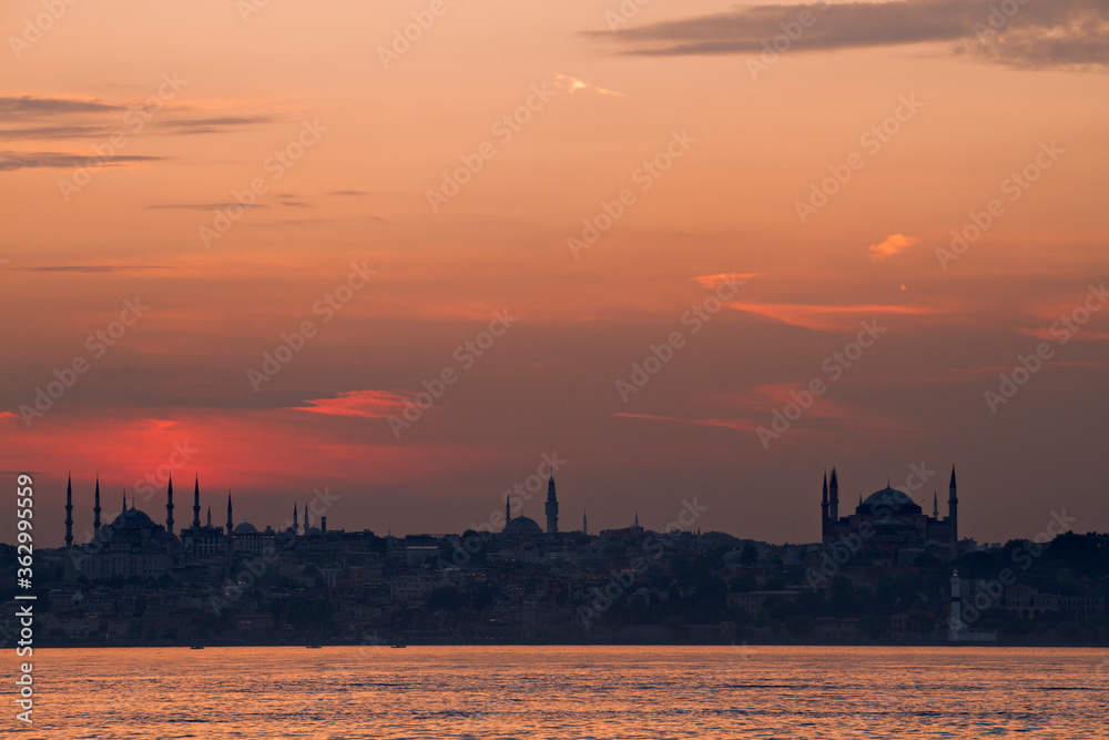Silhouette of Istanbul with the domes and minarets of Blue Mosque and Hagia Sophia, at the sunset, from Bosphorus, Turkey