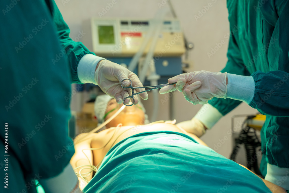 Doctor passing medical tool to surgeon at work in operating room. Doctor passing medical tool to surgeon at work in operating room.