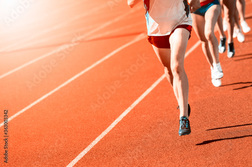 Athletics people running on the track field. Sunny day