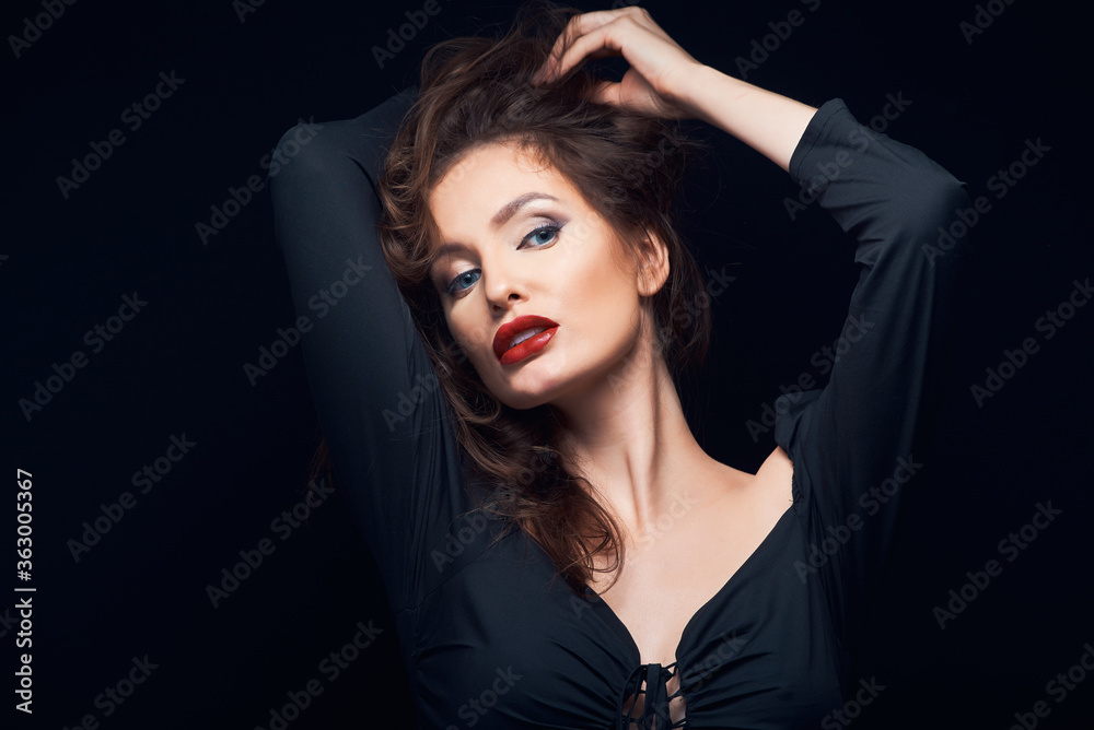 beautiful fashion portrait of a lovely woman in a dark dress on a black background