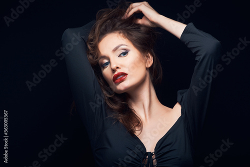 beautiful fashion portrait of a lovely woman in a dark dress on a black background