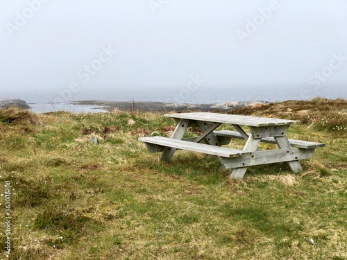 A picnic table on a deserted ocean coast. 