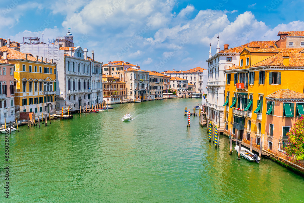 Venice, Italy - june 29th 2020 - The quiet Grand Canal with a single boat sailing seen from the Ponte dell Accademia bridge on a sunny Corona day in summer