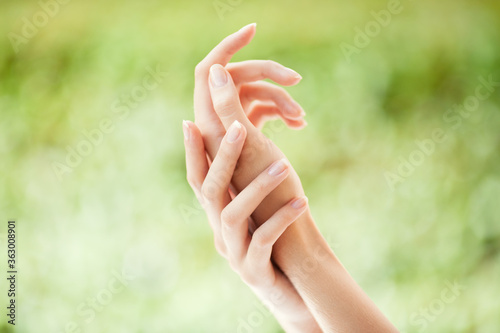 Beautiful female hands on a natural green background
