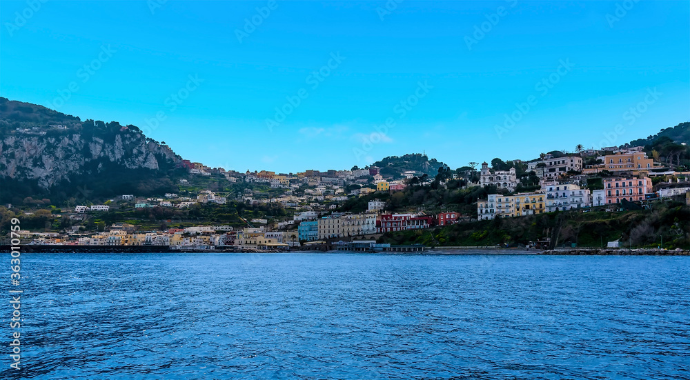 Capri town peeps out from the hilltop above Marina Grande on the island of Capri, Italy