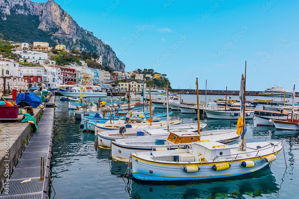 Traditional fishing boats moored in the inner the harbour of Marina Grande with Mount Solaro in the distance on the island of Capri, Italy