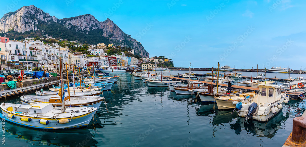 A panorama view of boats moored in the inner the harbour of Marina Grande with Mount Solaro in the distance on the island of Capri, Italy