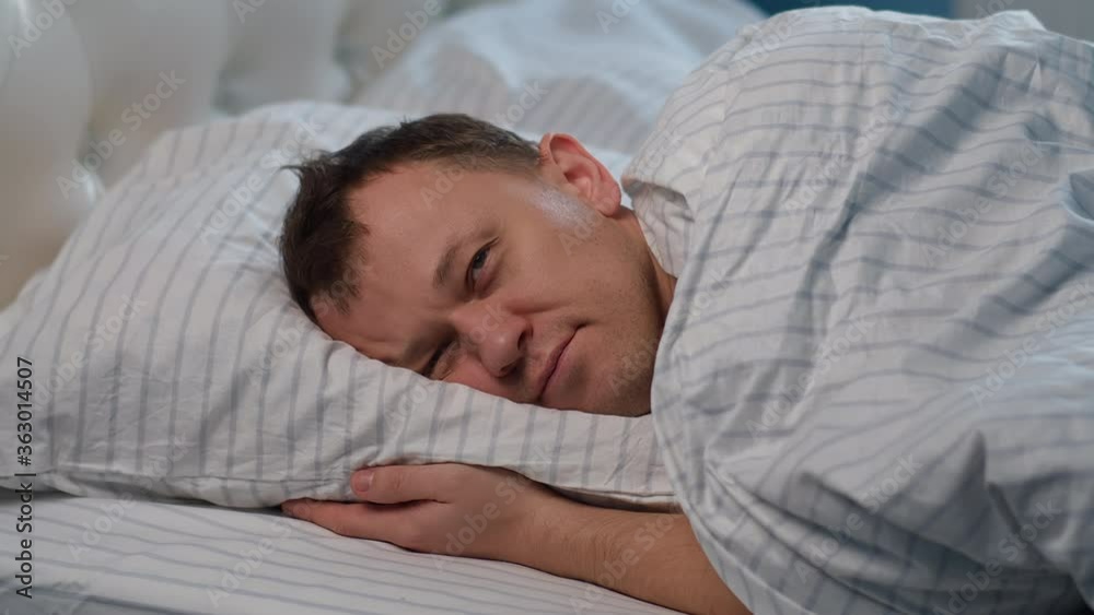 A man lies on the bed, tossing and turning, cannot sleep, gets up A man lies on the bed, tossing and turning, cannot sleep, gets up