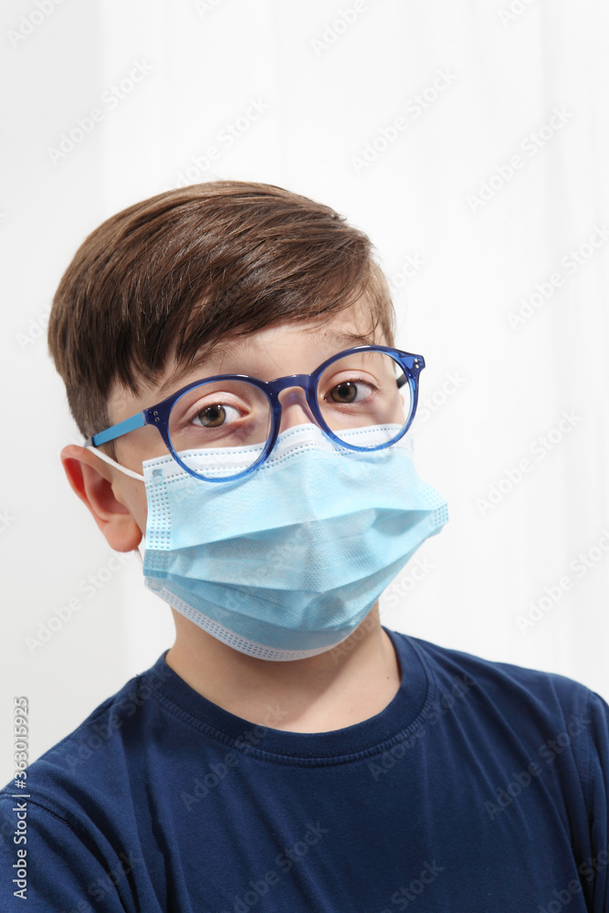 Child in a Medical Mask. Close-up portrait with a surgical mask on face isolated on white background, corona virus covid 19 protection Child in a Medical Mask. Close-up portrait with a surgical mask on face isolated on white background, corona virus covid 19 protection