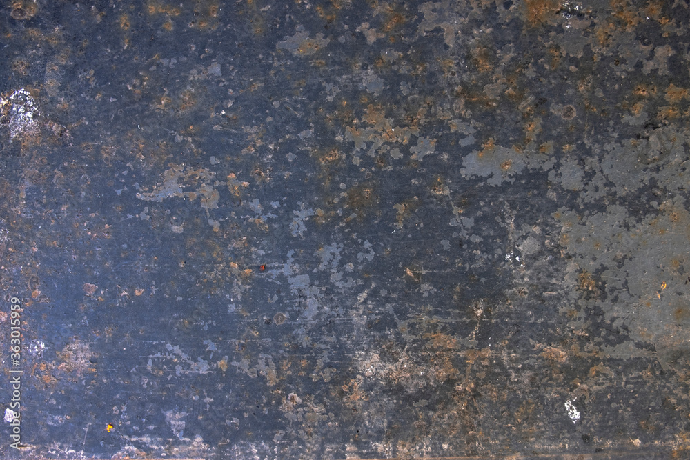 old rusty metal plate with peeling black paint. rough surface texture