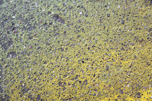 gray granular asphalt with a bright gradient of yellow paint. rough surface texture