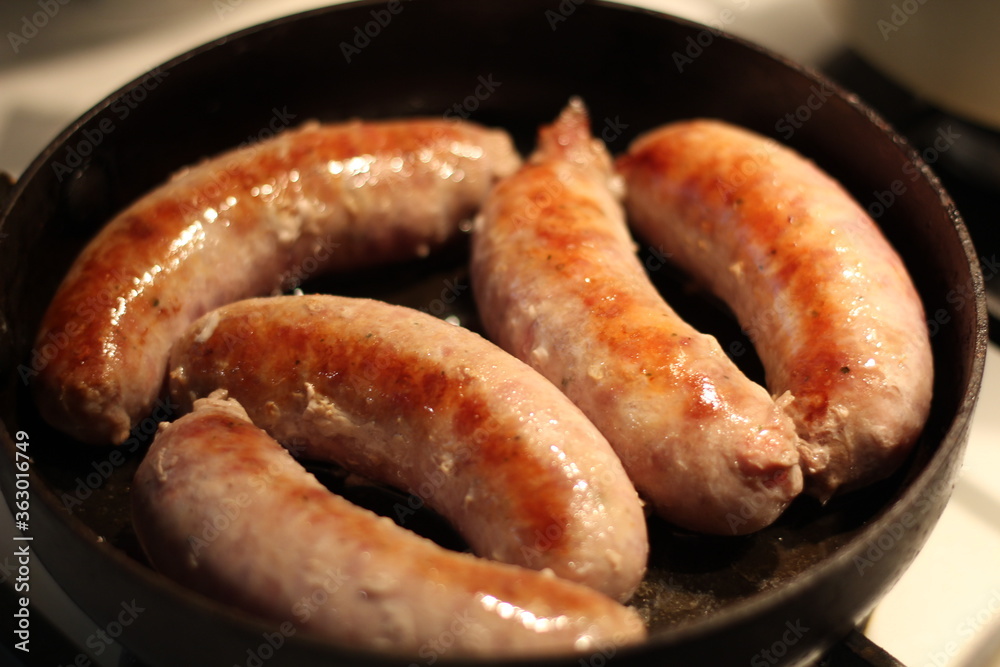 Soft focus photo. Fried sausages on the pan. Unhealthy breakfast. English and German style cuisine. Soft focus photo. Fried sausages on the pan. Unhealthy breakfast. English and German style cuisine.