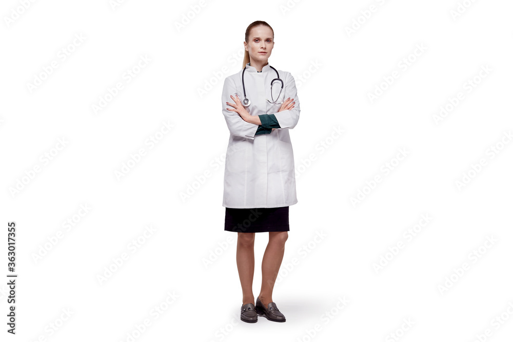A female doctor, looking at the camera, puts a medical mask on her face. A female doctor, looking at the camera, puts a medical mask on her face.