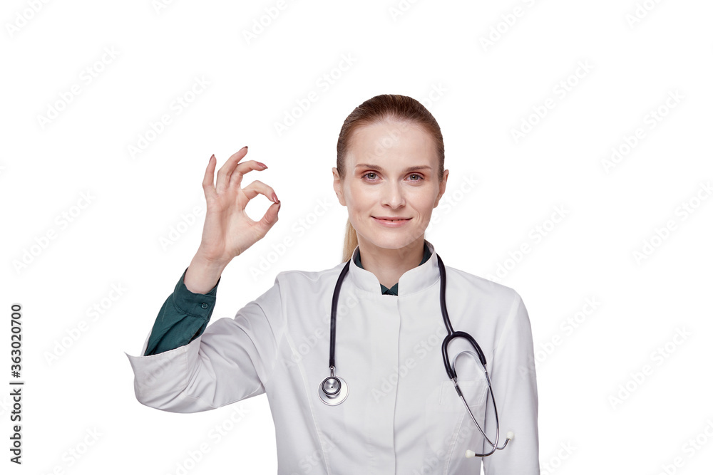 Beautiful woman doctor in a medical coat shows a gesture everything is super, ok Beautiful woman doctor in a medical coat shows a gesture everything is super, ok