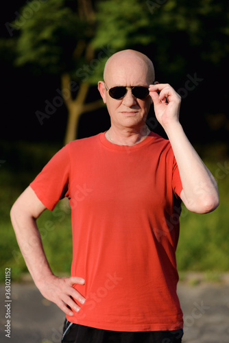Old man wearing sunglasses and summer clothes. High quality photo