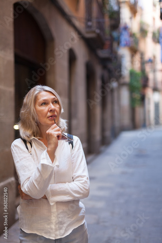 A woman walks and enjoys the beauty of a medieval city.