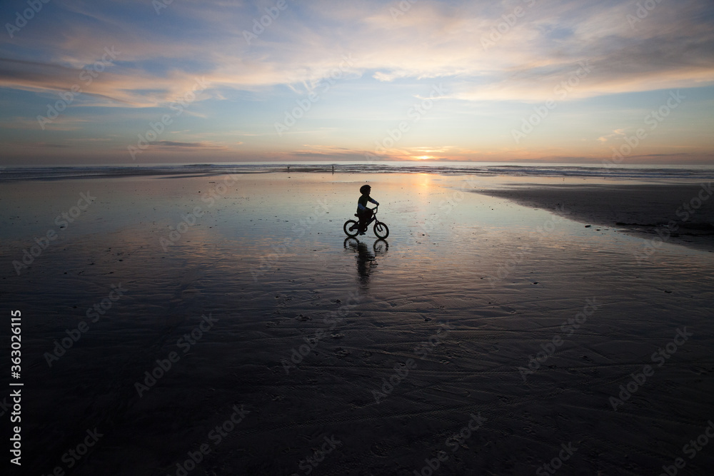 silhouette of child on bicycle 