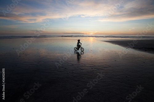 silhouette of child on bicycle 