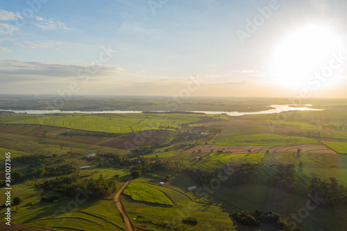 aerial view of plantations with a river in the background at sunset