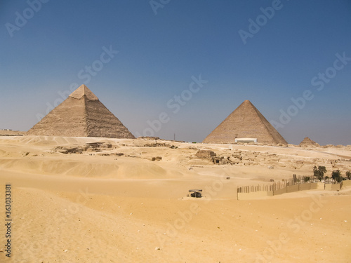 The mysterious old legacy of ancient Egypt - the Greatest wonder of the world, the Egypt pyramids and the stone Sphinx on the Giza platou in endless sands of the Sahara desert