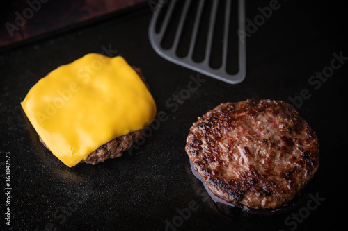 cooking burger patty on iron pan