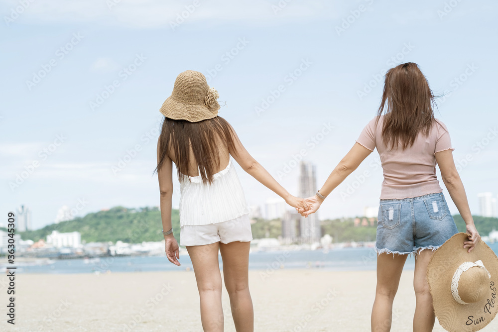 two women touching hands on the beach, vacation, summer time
two women touching hands on the beach, vacation, summer time