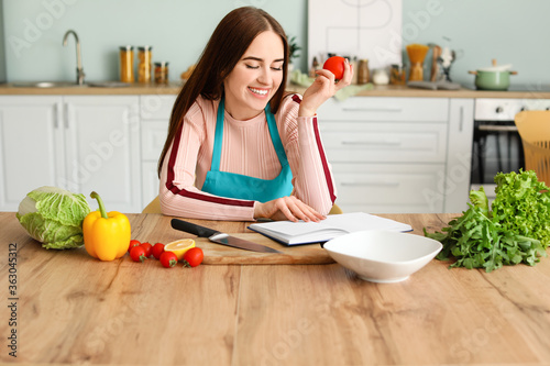 Young woman with recipe boo...