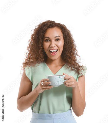 Beautiful young African-American woman with hot tea on white background