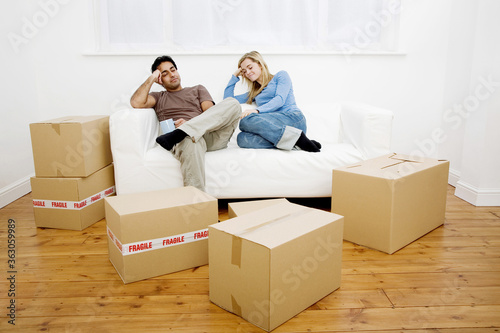 Couple napping on the couch with boxes on the floor