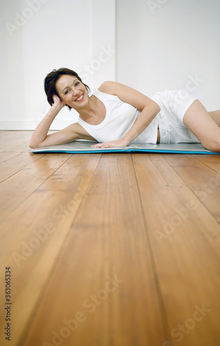 Woman lying on yoga mat