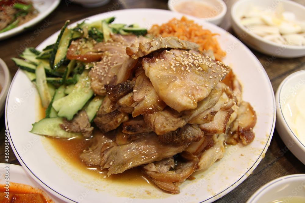 Korean style braised pork belly with the side dishes cucumber and edible jellyfish at Korean restaurant, South Korea Korean style braised pork belly with the side dishes cucumber and edible jellyfish at Korean restaurant, South Korea